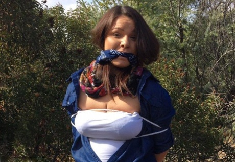 Полностью одетый толстяк расколот, с кляпом во рту и связанный веревкой в заросшем кустарником лесу 13